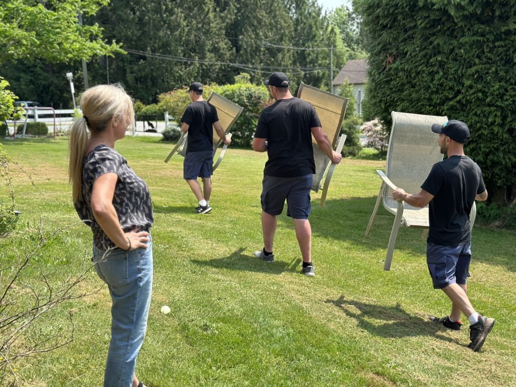 Big Phil's Rubbish Removal crew carrying chairs to the truck