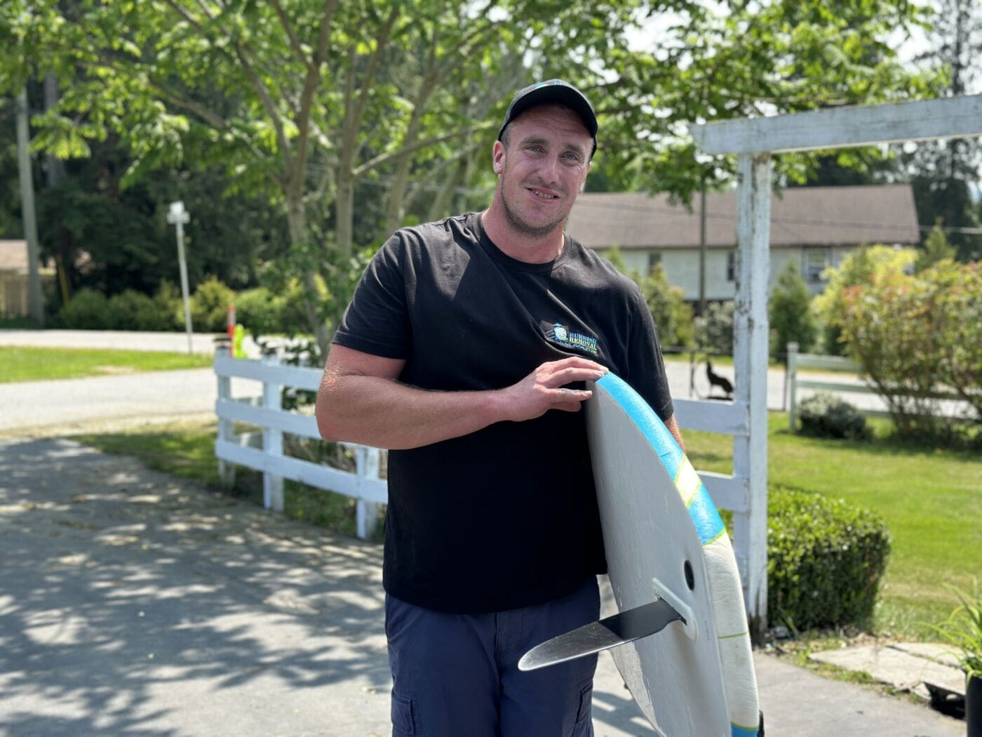 Big Phil's Rubbish Removal crew in Port Coquitlam carrying a surf board